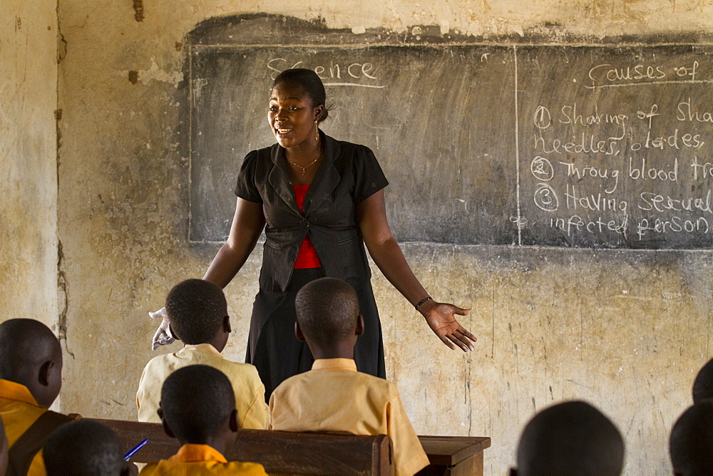 A Female Teacher Teaching Science To A Classroom Of