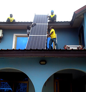Brighten Ghana, a renewable energy company, installs solar panels for a family home.
