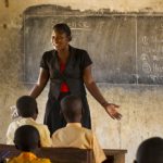 A female teacher teaching science to a classroom of students at a primary school, Ghana.