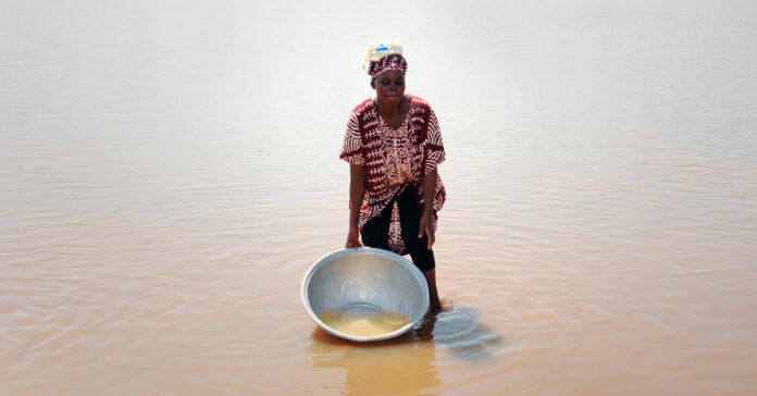 Image: A woman attempts to fetch drinking water from a river. But the water is contaminated. Gold mining in Ghana's rivers has literally destroyed almost all water bodies. Drinking water is becoming a scarcity.