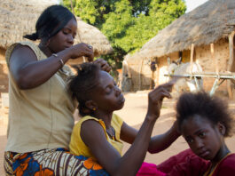 Young ladies of Koumbadiouma braid each other's hair. Kolda, Senegal.